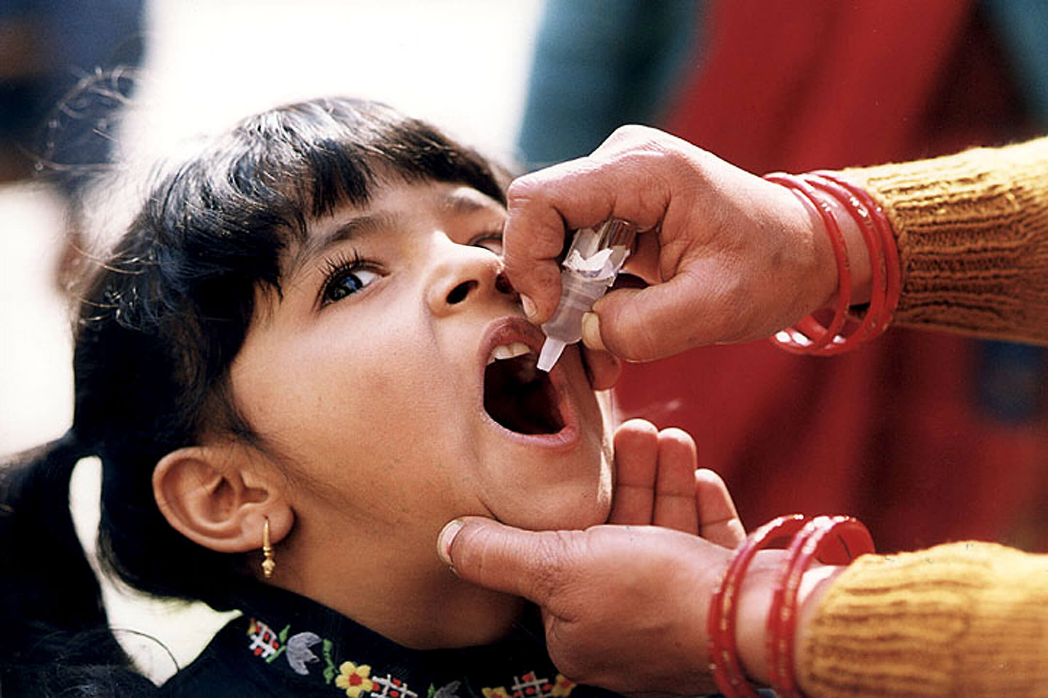 Niña tomando la vacuna oral contra la polio